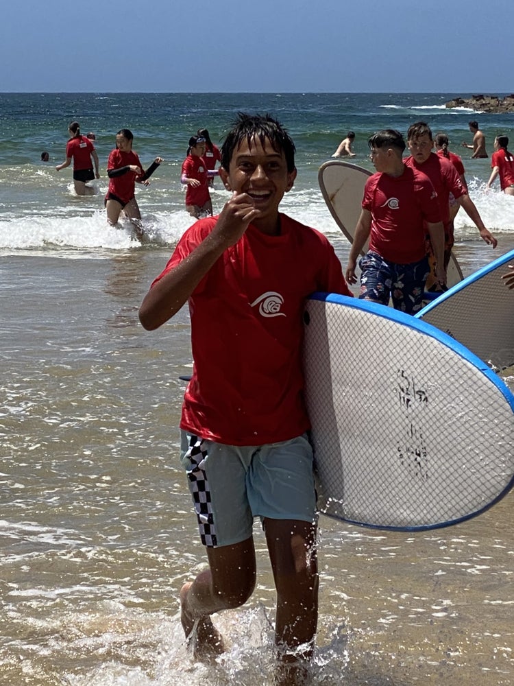 Year 6 students with surfboards at the beach