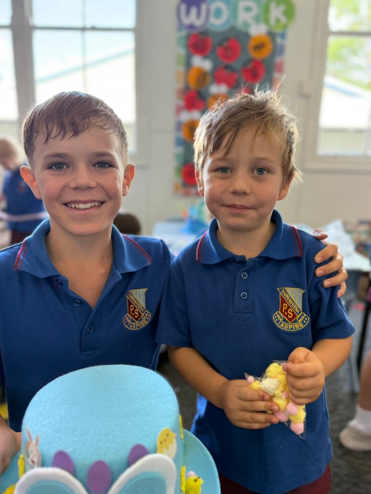 Male Year 6 and kindergarten students decorating easter hats