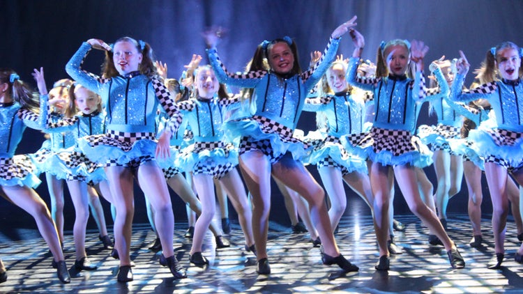 Photo of Year 3 and 4 female dancers in blue costume dancing