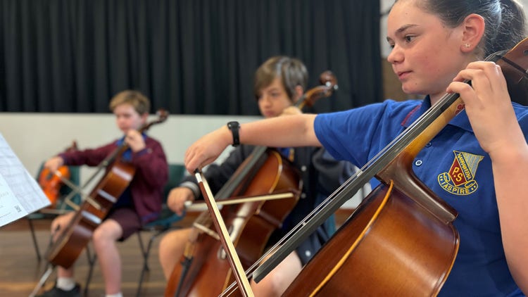Photo of female and male Year 6 students playing the cello